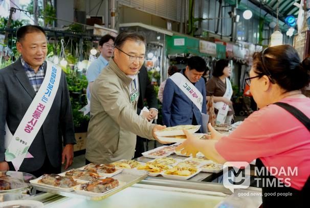 면목시장에서 상인과 이야기를 나누며 장보기 중인 류경기 중랑구청장의 모습