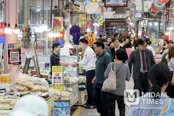 오언석 도봉구청장이 지난 26일 지역 내 한 전통시장을 찾아 상인과 손을 맞잡고 있다.