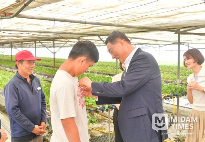 7월 김한종 장성군수가 외국인 계절근로자에게 한글 이름 명찰을 달아주고 있다.
