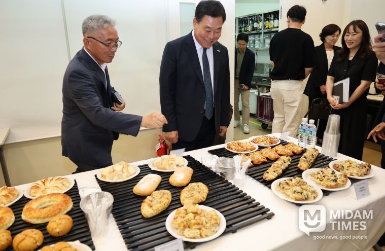 지난 7월 무안군-신세계푸드 협약식에서 무안 양파빵 제품을 살펴보는 김산 군수