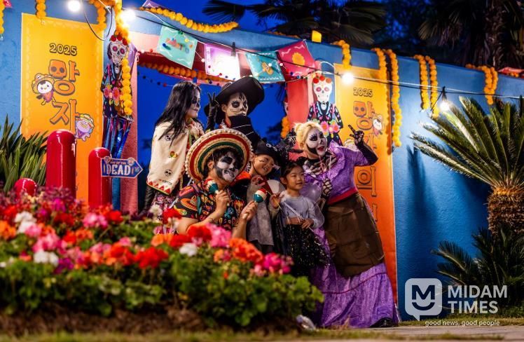 지난 25일 순천만국가정원에서 열린 ‘멕시코 망자의 정원 축제’에서 코스프레 복장을 한 배우들과 함께 사진을 찍는 아이들.