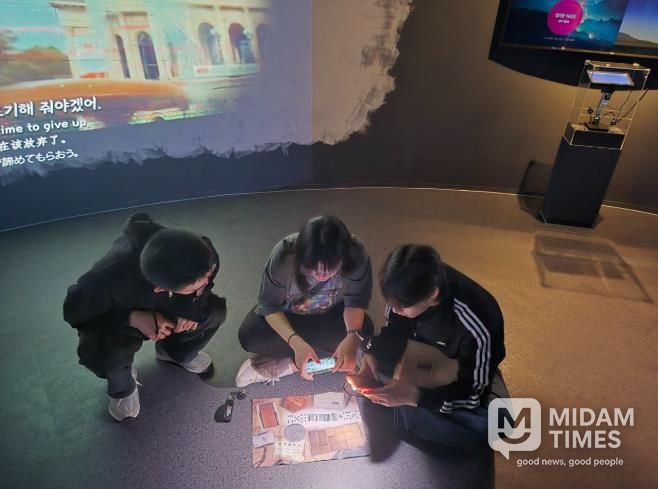 참여자들이 스마트기기와 실물 단서를 활용해 미션을 해결하는 방탈출형 체험 콘텐츠 ‘용화향도 시즌2’의 한 장면