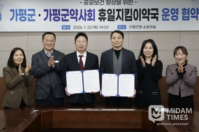 서태원 가평군수(사진 왼쪽에서 세번째)와 안병현 가평군약사회 회장(〃 네번째) 등이 22일 휴일지킴이약국 운영 협약식 후 협약서를 보이며 기념촬영을 하고 있다.