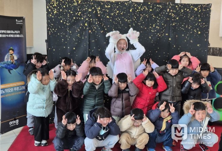 아이들이 공연 출연자와 함께 기념촬영을 하고 있다.