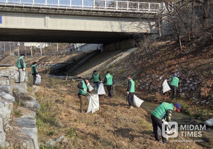 새마을협의회 위원들이 원당천 일대 환경정비를 하고 있다.