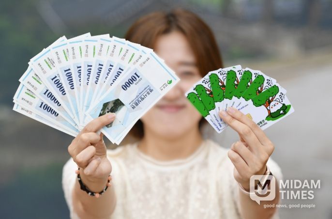 영주사랑상품권은 3월 1일부터 영주사랑상품권 할인율을 12%로 상향한다(영주사랑상품권.체크카드를 들고 있는 시민 모습)