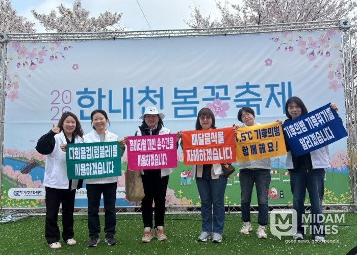 지난 11일 한내천 봄꽃축제에서 1.5℃ 기후의병들이 '2026 탄소중립 실천 모니터링'을 진행하고 기념사진을 촬영하고 있다.