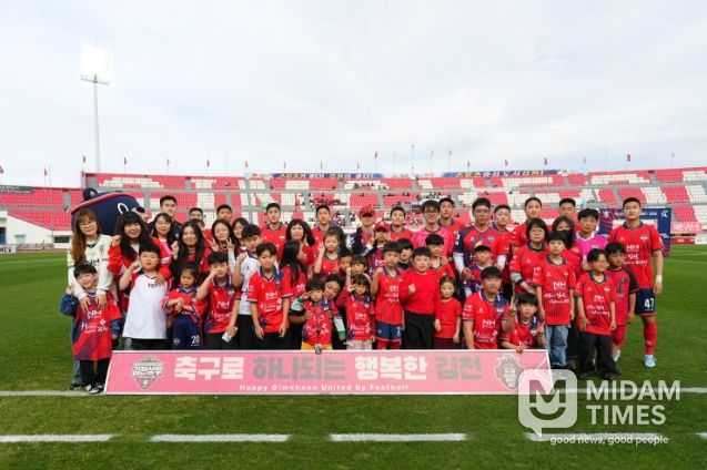 4월 12일 7R 안양전 홈경기에서 김천상무 선수들과 플레이어 에스코트 참가자들이 단체사진을 찍고 있다.